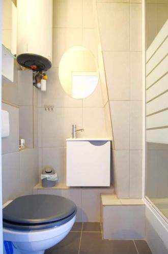 une salle de bain avec des toilettes bleues et un lavabo dans l'établissement Cosy Studio in Montorgueil, à Paris