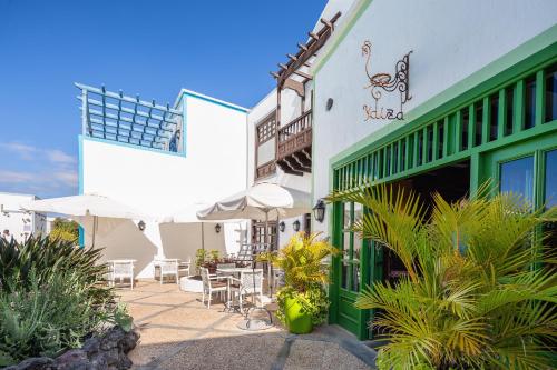 a building with a patio with tables and chairs at Hotel LIVVO Volcán Lanzarote in Playa Blanca