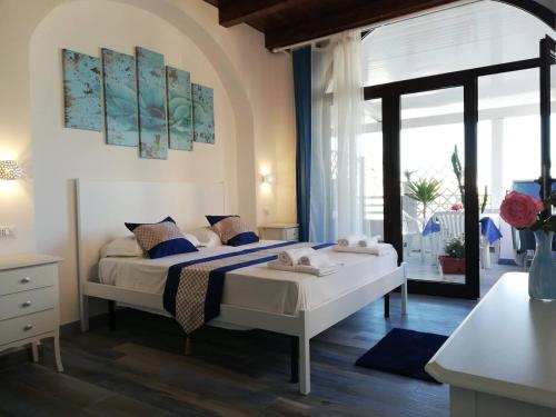 a hotel room with two beds and a large window at Mir Mar in Lampedusa