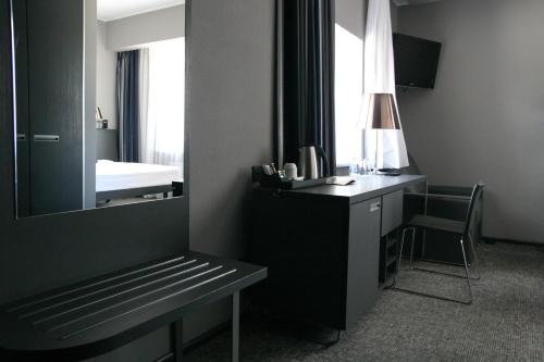 a room with a mirror and a desk and a bed at Mercure Kyiv Congress in Kyiv