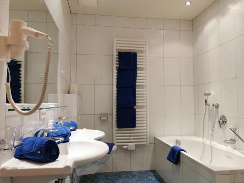a bathroom with two sinks and a tub and a bath tub at Hotel Garni Schönblick in Sölden