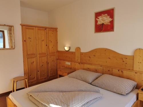 a bedroom with a bed with a wooden headboard at Hotel Garni Schönblick in Sölden
