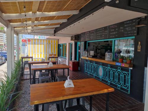 um restaurante com mesas e cadeiras de madeira e um balcão em VIAJERO Posada & Hostel Punta del este em Punta del Este