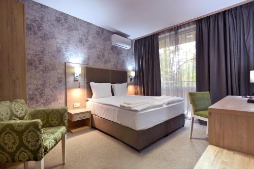 une chambre d'hôtel avec un lit, une table et des chaises dans l'établissement Green Hill Hotel, à Stara Zagora