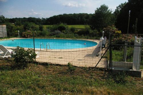 une grande piscine entourée d'une clôture. dans l'établissement Chambres d'Hotes du Maine, à Lalinde