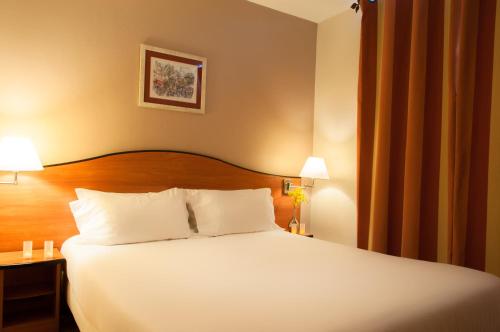 a hotel room with a bed with white pillows at Hotel Eden Montmartre in Paris