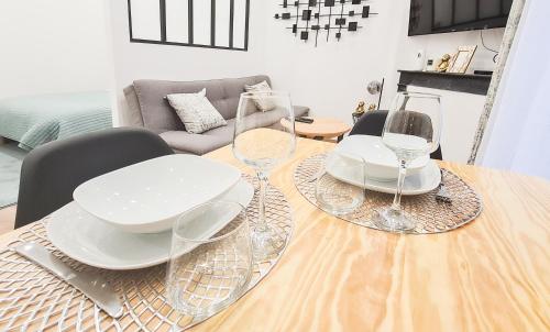 una mesa con tres platos y copas de vino. en Le Petit Cosy /Proche Disney - Paris / wifi - Netflix, en Meaux