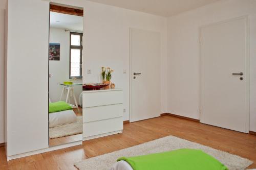 1 dormitorio con paredes blancas y espejo en Privatzimmer Othmarsweg, en Naumburg