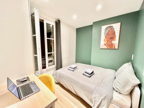 a bedroom with a bed and a desk with a laptop at CLICHY QUARTIER VICTOR HUGO - Superbe appartement entièrement rénové in Clichy