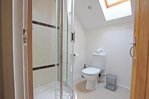 a bathroom with a toilet and a shower at Grooms Cottage in Kent