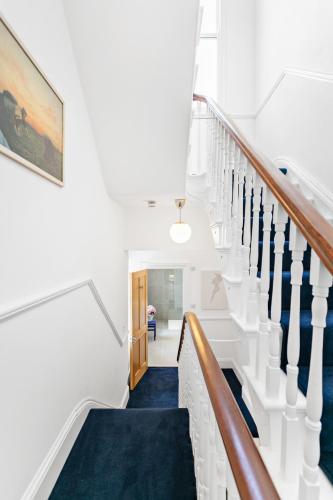 a staircase in a house with a blue carpet at Hoe Park House, Sleeps 10, Historic, Central, Near Excellent Dining, Bars & Seafront in Plymouth
