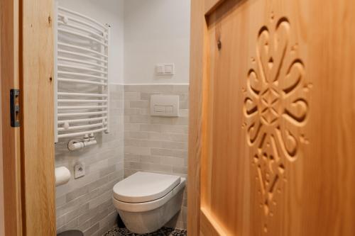 Apartament Białka في بيالكا تاترزانسكا: حمام مع مرحاض وباب خشبي