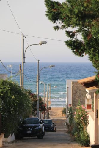 a street with cars parked on the beach at Mare Nostrum TF in Tre Fontane