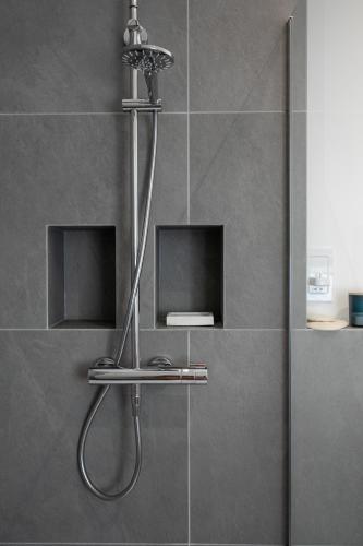 a shower with a shower head in a bathroom at Hoe Park House, Sleeps 10, Historic, Central, Near Excellent Dining, Bars & Seafront in Plymouth