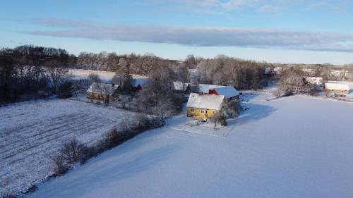 eine Luftansicht eines Hauses auf einem schneebedeckten Feld in der Unterkunft Yxnaholma Rum in Höör