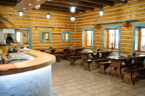 un restaurante con paredes de madera, mesas y ventanas en Penzion Zbojník, en Terchová