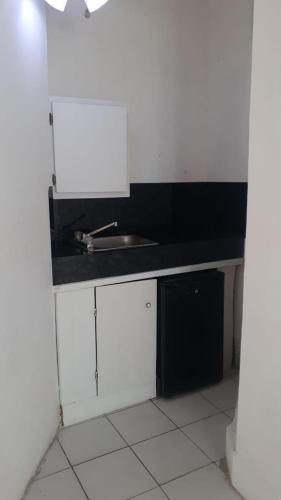 a white kitchen with a sink and a counter top at Calinago Friendly Family Sxm in Philipsburg