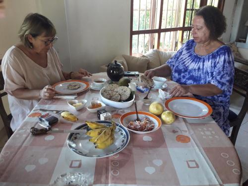 two women sitting at a table with plates of food at Sea Front Hikkaduwa in Hikkaduwa