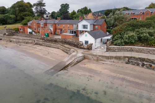 an aerial view of a town with houses and a body of water at For Sea Lovers ! Coastguard Boat House right on Belfast Lough in Newtownabbey