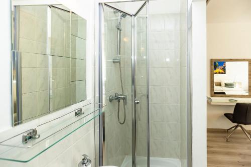 a shower with a glass door in a bathroom at Dobó Vendégház in Eger