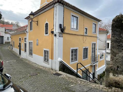 a white building with a black and white checkered roof at Sintra1012 Boutique Guesthouse in Sintra
