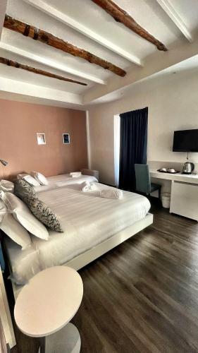 a bedroom with a large bed and a table at Palazzo Cappuccini Art Relais in Naples