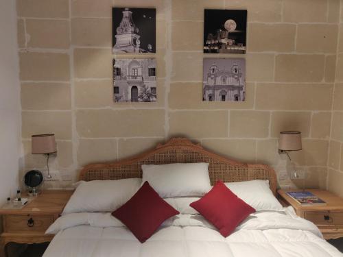 a bedroom with a bed with two red pillows at Central 214 Boutique Hotel in Hamrun