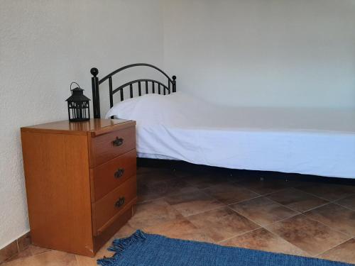 a bedroom with a bed and a wooden dresser with a white bedspread at Gevgelija Central in Gevgelija