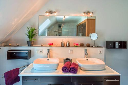 a bathroom with two sinks and a mirror at Ferienhaus Dieboldsberg in Alpirsbach