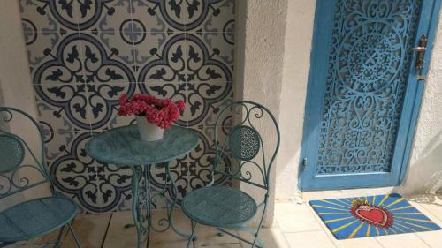 a table and chairs with a vase of flowers on it at Mi Casa Tu Casa - Dead Sea in Vered Yeriho