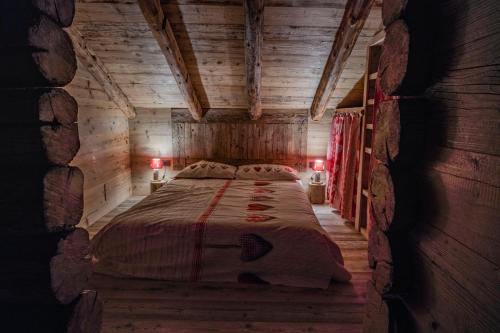 a bedroom with a bed in a wooden cabin at Rascard Monterosa in Champoluc