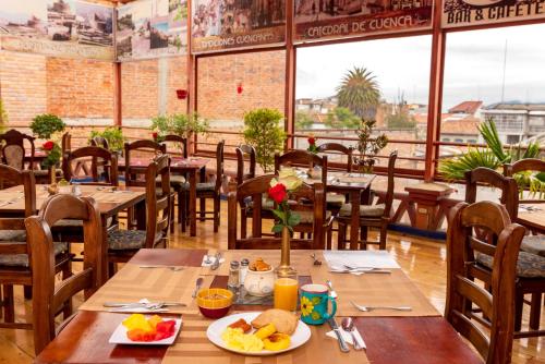 a restaurant with wooden tables and chairs with food on them at Hotel Boutique Los Balcones in Cuenca