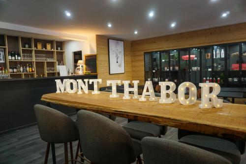 a table in a restaurant with a sign that reads not thatotin at Hôtel Mont Thabor Serre Chevalier in La Salle Les Alpes