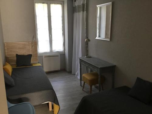 une chambre avec deux lits et un bureau et une fenêtre dans l'établissement ALS locations calvet françoise, à Jonzac