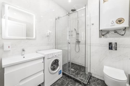 a bathroom with a washing machine and a shower at 20 Deribasivska Design Apartment in Odesa