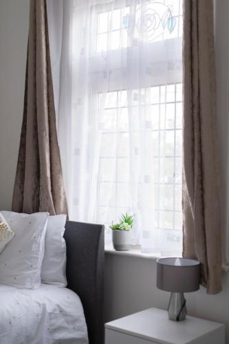 a bedroom with a bed and a window with a plant at Fortified Beautiful Three bedroom House in Plumstead