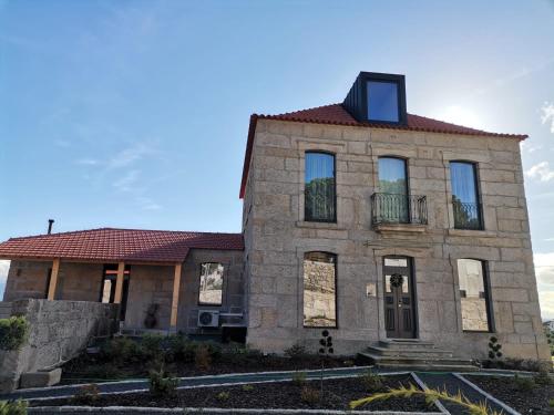 una antigua casa de piedra con una ventana en el techo en Casa Nova Rural en Nelas