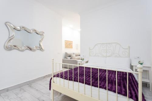 a white bedroom with a bed and a couch at Apartamento Carmen in Málaga