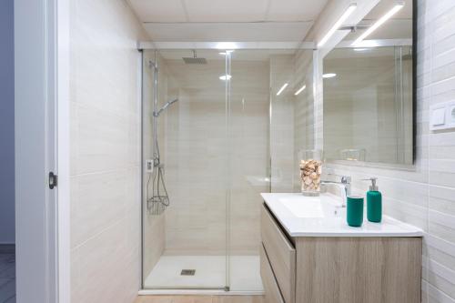 a white bathroom with a shower and a sink at Apartamento Carmen in Málaga
