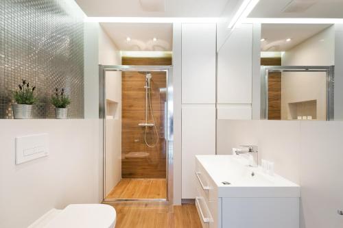 a bathroom with a shower and a toilet and a sink at Central Apartments by Bed&Bath in Kraków