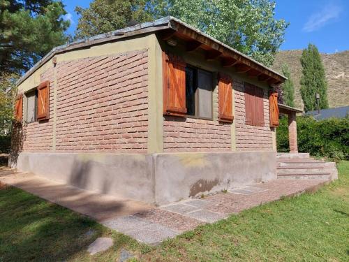 a small house with open windows in a yard at Cabaña de montaña in Potrerillos