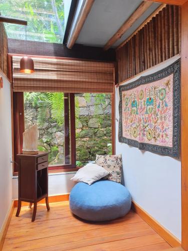 a room with a blue bean bag chair and a window at Pousada Tekoá Indiana in Cachoeiras de Macacu