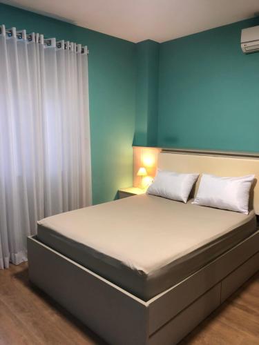 Apto no centro da cidade mais alemã do Brasil في بوميرودي: غرفة نوم بسرير كبير مع ستائر بيضاء