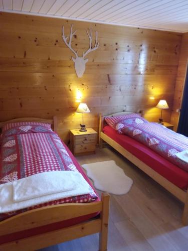 a bedroom with two beds and a deer head on the wall at Apartment mit Traumblick im Haus Olympia in Grächen