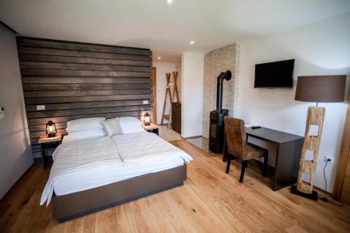 a bedroom with a large bed and a desk with a computer at Penzion Repnik in Kamnik