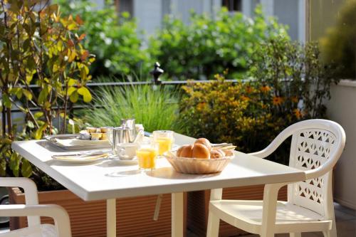 a table with a bowl of bread and glasses of orange juice at Elite in Lausanne