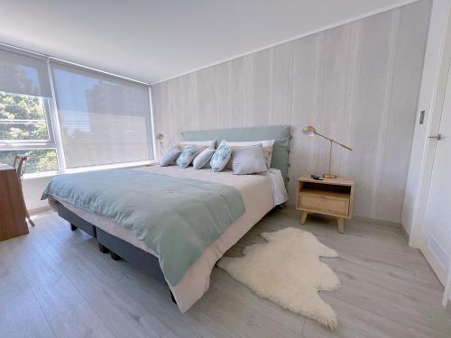 um quarto com uma cama grande e um tapete em DEPARTAMENTO CON ESTACIONAMIENTO em Temuco