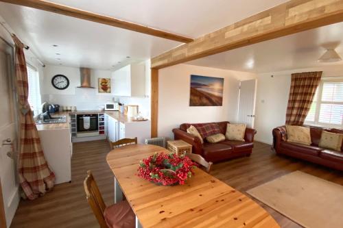 a living room with a table and a couch at Beach View Cottage in Isle of Gigha