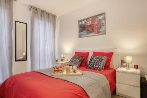 - une chambre avec un lit rouge et un plateau de nourriture dans l'établissement Luxueux Paris - Bagnolet - Les Lilas-Parking Gratuit, à Bagnolet