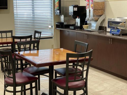 a kitchen with a table and chairs and a refrigerator at Days Inn by Wyndham Indio in Indio